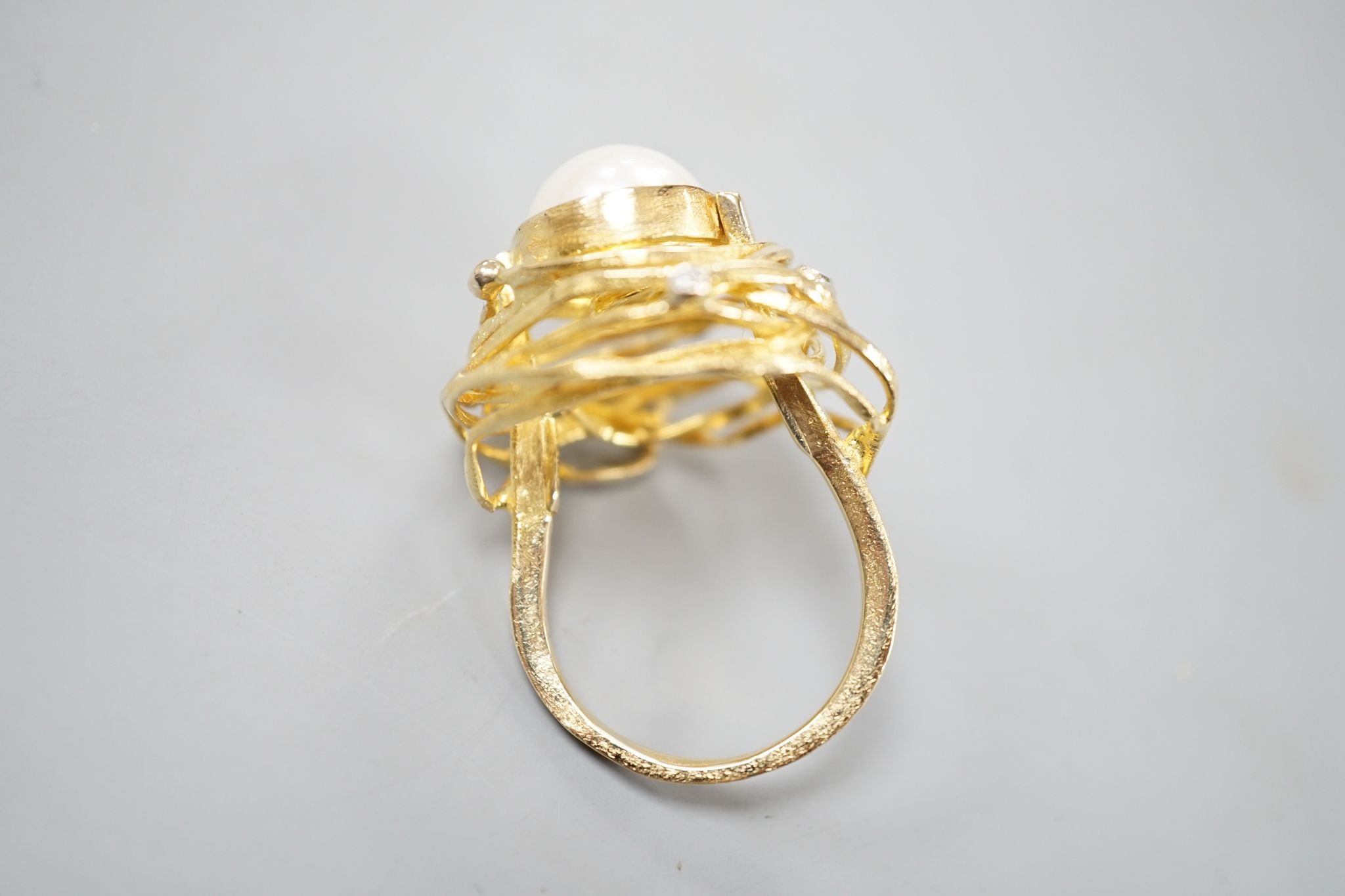 A modern 750 yellow metal, mabe pearl and diamond chip set modernist dress ring, size Q, gross 13.2 grams.